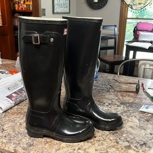 Hunter tall glossy black rain boots.